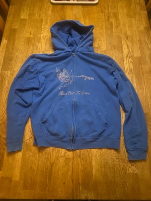 Blå Rhinestone zip hoodie - Hej, jag säljer en stilren blå Rhinestone zip hoodie. Hoodien är väldigt bekväm och har inga defekter. Den är rent av sagt i väldigt bra skick. Pris kan diskuteras. 