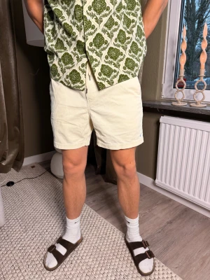 Ljusgula manchester shorts Polo Ralph Lauren - Säljer ett par ljusgula manchester shorts från Polo Ralph Lauren. De har normal passform, elastisk midja med snörning och diskret broderad logga i blått på benet. Klassisk design med fickor fram och bak, perfekta för sommarens alla dagar.