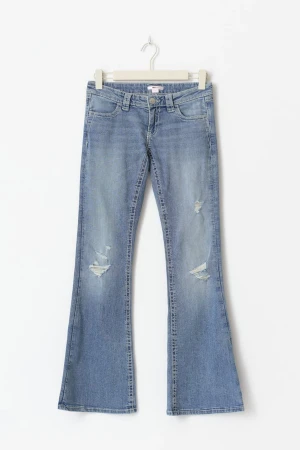 Blå bootcut jeans med broderade fickor - Snygga ljusblå bootcut jeans med slitningar framtill och detaljerade broderier på bakfickorna. Dem är helt oanvända och är i storlek 164. Jeansen har klassisk femficksdesign, låg midja och är tillverkade i mjukt denimtyg. ☺️☺️