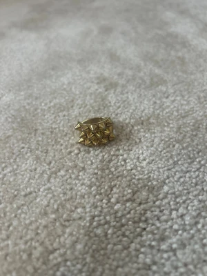 Guldfärgad Edblad ring med nitar - Cool ring från Edblad i guldfärgad metall med flera små, spetsiga nitar runt hela ringen. Ringen är i storlek 18.50💞