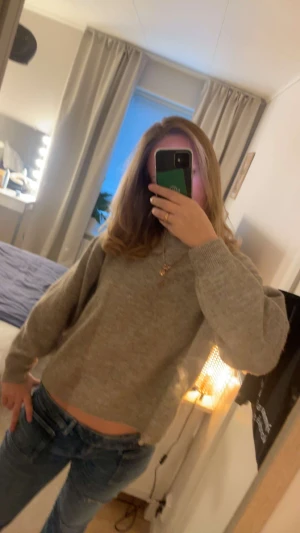 Beige stickad tröja från H&M - Mysig beige stickad tröja från H&M i storlek M. Tröjan har en klassisk rund halsringning, ribbade muddar och en relaxed passform. Perfekt att slänga på sig när det är kyligt ute. Enkel och stilren design som funkar till allt.