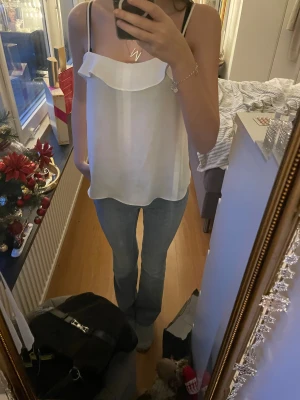 Vitt linne med vålang upp till🤍 - Säljer ett vitt linne från h&m med volang upp till, funkar till allt, basic men ändå lite extra, jätte fin till sommaren, luftig och skön💗