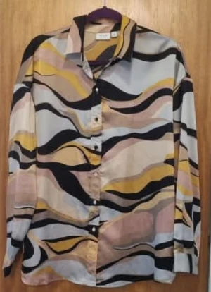 Mönstrad skjorta från Vila - Säljer en långärmad skjorta från Gina Tricot med vågigt mönster i svart, beige, gul och ljusrosa. Skjortan har klassisk krage och knappar framtill. Materialet är mjukt och känns lätt mot huden, perfekt för dig som gillar färg och coola prints.