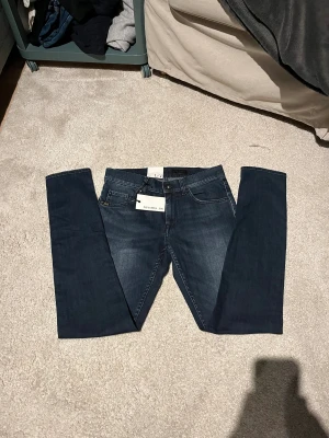 Mörkblå Tiger of sweden jeans W30 L32 - Helt nya snygga mörkblå jeans med smal passform och smal fot från tiger of sweden. Klassisk femficksmodell med diskret tvätt och raka bakfickor. Perfekt för dig som gillar en modern och stilren look. Materialet är jeans och färgen är mörkblå.