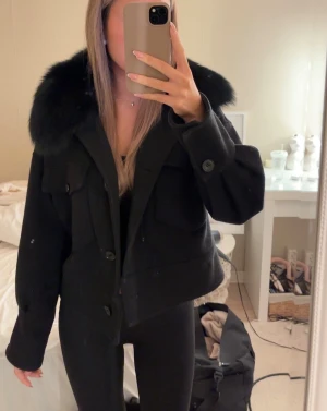 Svart Meotine Kappa -  Svart jacka med äkta päls. Kappan är använd men ser fortfarande fin ut, den är nopprig på vissa ställen som man kan se på bild 3 och 4. Storlek S/M 