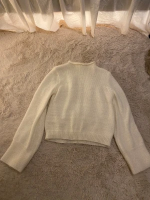 Vit stickad tröja från NA-KD - Mysig vit stickad tröja från NA-KD i storlek M. Tröjan har ribbade muddar och en enkel rund halsringning. Tröjan sticks inte alls och den har raka vida ärmar💞