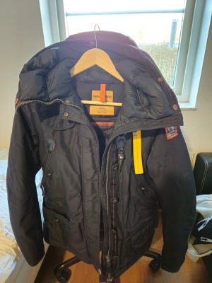Mörkblå Parajumpers vinterjacka - Säljer en mörkblå Parajumpers vinterjacka i storlek S. Den är väldigt liten. Ena jackärmen har lite slitage men bortsett från det så är den i bra skick. Har ej kvitto men har bevis/mail både från certilogo som visar på att den är äkta och att qr+clg koden visar den som autentisk. 