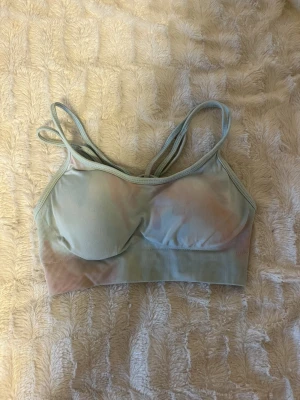 Sport topp  - Säljer min sport-bh i ljusblått med pastellfärgade inslag och dubbla axelband. Den har bra support och är köpt i usa