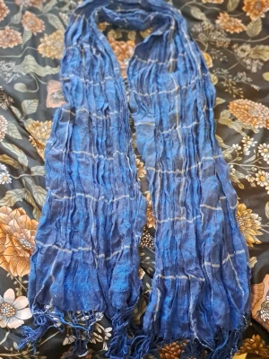 Blå scarf/halsduk- väldig tjusigt - Blå scarf med ett rutigt mönster och fransar. I gott skick och sparsamt använd.  Väldigt tjusigt att använda till vardags, fina tillfällen och när det kallt ute.   Skickas via posten men köpare står för frakten. Vid övriga frågor skicka gärna meddelande.  Lämnar självklart god omdömen om köparen gör det.  Kolla in gärna på mina andra annonser!