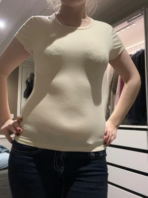 Gul  tight t-shirt i bomull - Säljer en enkel och stilren gul t-shirt med rund hals och korta ärmar. Modellen är tight och sitter snyggt mot kroppen. Materialet är mjuk bomull som känns skönt mot huden. Perfekt att matcha med jeans eller shorts för en clean look.