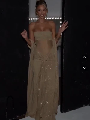 Glittrig guldig maxiklänning från babyboo - Perfekt som nyårsklänning, säljer för att jag hittat en annan. Skickar samma dag som köp. Aldrig använd, har egna bilder. Hade lämnat tillbaka men då får man endast presentkort tillbaka