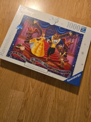 Disneypussel 1000bitar skönheten och odjuret  - Bilderna visar ett pussel från Ravensburger med Disney-motiv från Skönheten och Odjuret. Tycker det är i mkt fint skick, ska vara komplett. 
