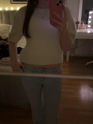 Vit stickad topp - Säljer en vit stickad topp med korta ärmar och croppad passform. Toppen har en mjuk känsla. Säljer för att den aldrig kommit till användning. Använd gärna köp nu