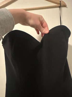 Jumpsuit superfin!! Stl 40 perfekt till nyår - Säljer en svart jumpsuit med axelband och snygg -ringning upptill. Jumpsuiten har ett wide fit och är långa med rak siluett. Materialet känns mjukt och har ett fint fall, perfekt för dig som gillar stilrena plagg med lite edge. Aldrig använd dock tvättad en gång :)