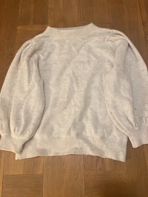 Ljusbeige stickad tröja KappAhl - Mysig ljusbeige stickad tröja från KappAhl i storlek S. Tröjan har puffiga långärmar, ribbad hals, muddar och nederkant. Materialmix med polyester, akryl, polyamid, alpacka, ull och elastan. Perfekt för kyliga dagar och enkel att matcha med jeans eller kjol. Pris kan diskuteras.