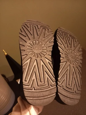 Svarta UGG boots i mocka strl 40 - Svarta UGG boots med mjukt och fluffigt foder på insidan. Yttermaterialet är mocka och sulan är grov med UGG-logga undertill. Klassisk rund tå och platt sula, perfekt för kalla dagar. Snygg och enkel design som är lätt att matcha med olika outfits använda ca 2 gånger,  verkligen jätte sköna å varma köpta på UGG sidan