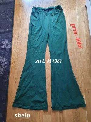 Gröna wide byxor från Shein strl: M - Säljer ett par gröna byxor från Shein i storlek M. Byxorna har en bred och flowy passform med utsvängda ben och hög midja. Materialet är mjukt och skönt, perfekt för en chill och avslappnad stil.