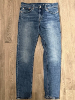 Levi’s 512 Jeans Blå W29 L32 - Blåa Levi’s 512 jeans i fint skick i storlek W29/L32. Mått - Midja: 40cm, Benlängd: 99cm. Modellen är 185cm & 63 kg. Hör av dig vid funderingar!🤩