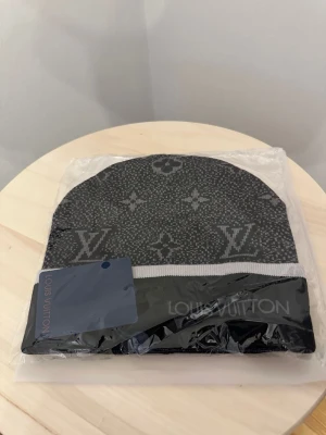 L.V svart mönstrad mössa - Säljer en helt ny mössa oanvänd, Storlek One size Fraktar snabbt inom 24h efter köp.Ställ gärna din fråga.