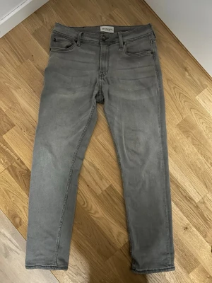 Grå jeans - Snygga grå jeans från Stock & Hank i rak modell. Storlek W29 L30. Klassisk femficksdesign och normal passform. Jeansen är tillverkade i mjukt bomullsmaterial med en lätt tvättad look. Perfekta till vardags för en clean och enkel stil.