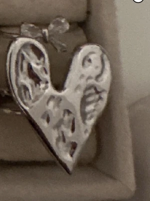 Ingen väst på bilden - Bilden visar inte någon väst utan ett smycke i form av ett hjärta.