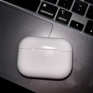 AirPods Pro - Apple AirPods Pro med trådlös laddningsetui. Bra skick med mindre repor på fodralet, hörlurarna är rena och fungerar utmärkt. Aktiv brusreducering och transparensläge för bästa ljudupplevelse. Perfekt för både musik och samtal. Observera att orginalförpackaningen och pluppar INTE tillkommer.  Jag har totalt 2 identiska par till salu – detta är ett av dem. Obs på detta par fungerar endast vänster airpod den högra behöver bytas ut