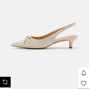 Vit/beige spetsklackar - Intressekoll på mina beige pumps från Anna Field med spetsig tå, låg klack och öppen häl. Skorna har en jättefin rosett framtill och är tillverkade i glansigt material som ger en stilren känsla. Perfekta för en fin middag eller en utekväll!