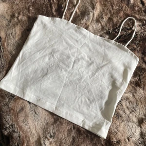 Vit crop top  med smala axelband - Säljer en enkel och fräsch vit crop top med smala axelband. 