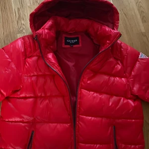 Guess pufferjacka - köpt i USA - 2 år gammal Guess vinterjacka köpt i USA med avtagbar luva. Använd i ungefär 1 vinter, och har därefter suttit fint och fridfullt i garderoben😊. Nypris på jacken var 315$ (ca3210kr)och säljs nu för 899. (I bilden är jag 187cm 77kg). Finns även i VIT!