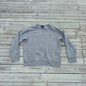 Grå sweatshirt från Ralph Lauren - Klassisk grå sweatshirt från Ralph Lauren med broderad logga på bröstet. Storlek 14-16 vilket motsvarar xs. Tveka inte på att skriva om ni har några funderingar. Priset är diskuterbart🙌