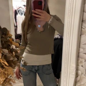 Grön ribbad långärmad topp - Supersöt topp! Ribbad och långärmad med v-ringning och knappar framtill. Säljes pga att den är lite för liten för mej. Använd fåtal gånger. Skriv om du har nån fundering🌸