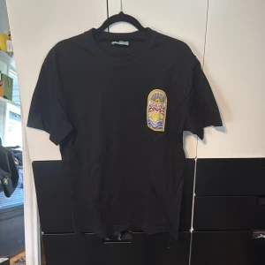 Casablanca tshirt - Svart t-shirt från Casablanca med stort färgglatt motiv på ryggen och mindre på bröstet. T-shirten har rund hals, korta ärmar och är gjord i mjuk bomull. 