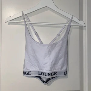 Vit Lounge linne crop top XS - Säljer ett linne från Lounge Underwear med fina detaljer i ryggen där banden korsas. Banden är justerbara för perfekt passform. Linnet är i ett dubbelt tyg, så det är inte genomskinligt, och materialet känns lyxigt och lite tjockare. Har en fin uringning och sitter riktigt snyggt på. Helt oanvänt och säljs inte längre på hemsidan.  Vänligen läs min bio innan du gör ett köp; där hittar du bland annat information om leveransprocessen med mera 😊  #Linne #LoungeUnderwear #XS #Oanvänt #FinPassform #S