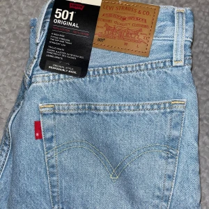 Levi's 501 ljusblå jeans 25/30 Helt nya - Klassiska Levi's 501 jeans. Jeansen är tillverkade i 100% bomull och har den ikoniska röda Levi's-taggen på bakfickan samt läderpatch i midjan. Perfekta för en avslappnad och tidlös look.   Nypris-1249