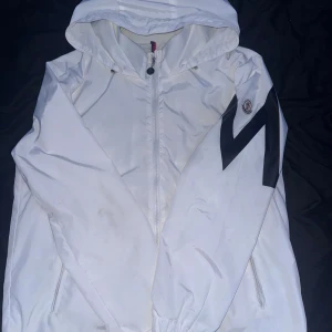 Moncler jacka  - Säljer denna sällsynta vita moncler windbreaker som är storlek 2 det är som S-M den är nästan helt oanvänd. Nfc Scan och sånt funkar såklart. 