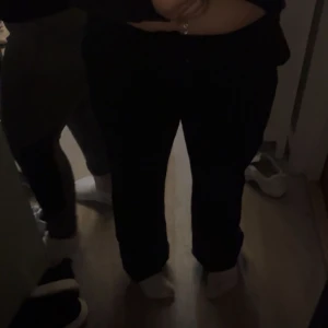 Svarta raka byxor - Svarta kostymbyxor med rak passform och normal midja. Klassisk stil som funkar till många olika outfits. Kostymbyxorna har en enkel design knappar på rumpan på fickorna detaljer och är tillverkade i ett mjukt material.