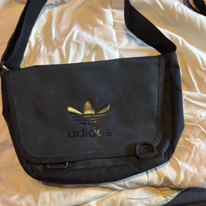 Säljer en adidas väska - Tja säljer min adidas väska då den inte kommer till användning längre. Den har fyra fack ett på baksidan två framme när man öppnar det största facket så finns det två exakt undrar själva adidas loggan. Inga skador eller märken. Köpte den för 500 för typ 3 år sen och har använt den ungefär fyra gånger.
