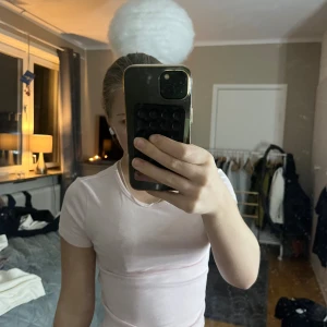 Ljusrosa t-shirt från Gina Tricot XS - En basic ljusrosa t-shirt från Gina Tricot, Daily Basics-kollektionen. Modellen är figurnära med korta ärmar och rund halsringning. Perfekt att styla med jeans eller kjol för en clean look.