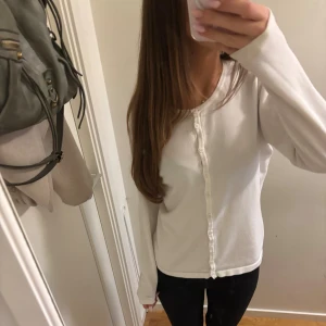 Vit kofta med knappar - Jätte fin vit långärmad kofta med rund hals och knappar.