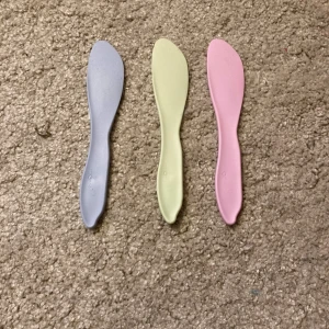 Smörknivar - Tre smörknivar i plast i olika färger. 10 kr för alla 3.