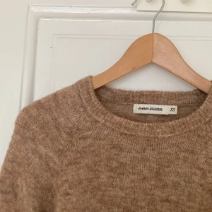 Beige stickad tröja Carin Wester XS - Mysig beige stickad tröja från Carin Wester i modellen Terja. Tröjan har rund halsringning och långa ärmar. Materialmix med alpacka, ull och polyamid ger en mjuk och fluffig känsla. Perfekt för lager-på-lager under kyliga dagar.