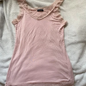 Rosa spetslinne  - Supersöt ljusrosa linnetopp från Voyelles med spetsdetaljer längs axelband, halsringning och nederkant. Står ingen storlek i men skulle säga S/M🙏