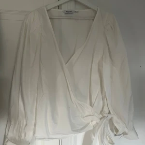 Vit omlottblus från Kappahl - Säljer en vit omlottblus från Kappahl med långa puffiga ärmar och knyt i sidan. Blusen har v-ringning. 