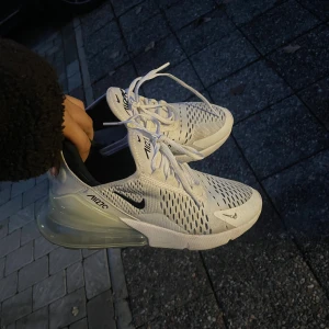 Nike Air Max 270 vita sneakers - Nike Air Max 270 sneakers i vitt med svarta detaljer. Använt ett par gånger, utan några skador. Storlek 39