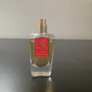 Fana Dora Kropp & Själ Parfym - Exklusiv parfym från Fana Dora Sweden med röd etikett och stilren design. Parfymen rymmer ca 47ml och har tvärt tappat bort korken o h därför säljer den för en lite billigare pris. Nypris 3100kr