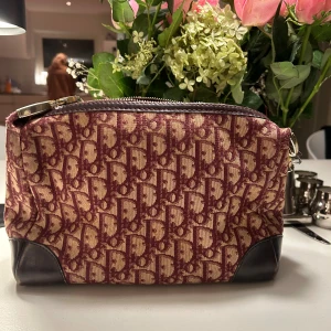 Dior väska - Säljer nu min älskade dior väska som är så snygg och unik! Den har justerbar rem så man kan välja längden själv på bandet. Lite sliten på vissa ställen med inget man lägger märke till, väldigt bra och fint skick utöver det. SÄLJER ENDAST VID BRA PRIS. Hör av er vid eventuella frågor