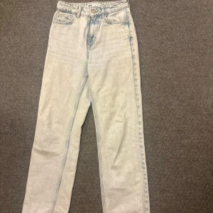 Ljusblå raka jeans från Zara - Säljer ett par ljusblå jeans från Zara med klassisk femficksdesign och raka ben. Jeansen har hög midja och är tillverkade i denim med en snygg tvättad look. Perfekta för en avslappnad och trendig stil.