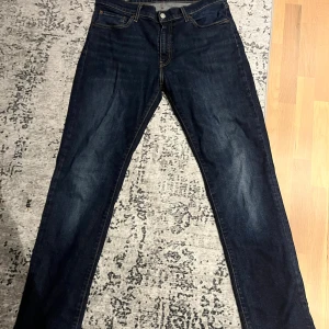 Levi's 511 mörkblå jeans - Säljer ett par Levi's 511 jeans i mörkblå tvätt med klassiska kontrastsömmar och femficksdesign. Jeansen har en slim passform och är tillverkade i slitstarkt denim. Perfekta för dig som gillar en tidlös och clean look. Priset kan diskuteras 