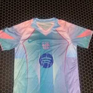 FC Barcelona x Nike pastell fotbollströja - Säljer en FC Barcelona x Nike fotbollströja i pastellfärger med klubbmärke och Spotify-logga på bröstet. Tröjan har korta ärmar, V-ringning och är tillverkad i lätt, ventilerande polyester. Färgskalan går i ljusblått, rosa och lila med grafiska linjer och detaljer. Bara höra av er vid frågor/funderingar Fraktar samma dag som köp🚚