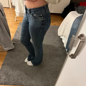 Blå bootcut jeans från Nelly, stl 36 - Snygga blå jeans från Nelly i storlek 36 med klassisk femficksdesign. Jeansen har bootcut-ben och normal passform, tillverkade i mjukt denimtyg. Perfekta för dig som gillar en tidlös look med lite utsvängda ben.